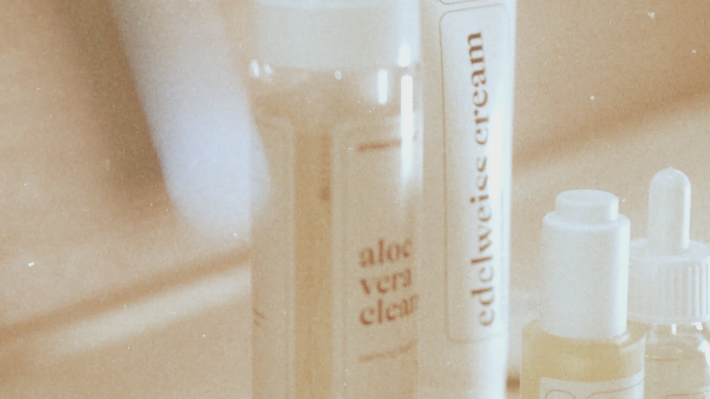 Vrouw loopt in een badkamer setting met allemaal Prescription Skincare producten om haar heen.